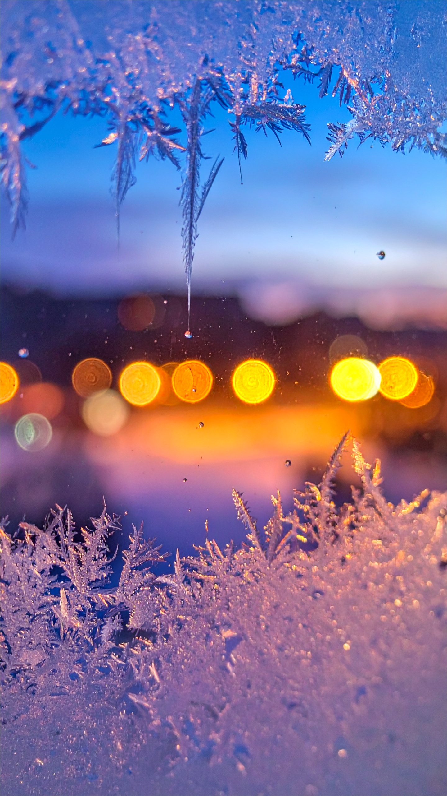 雪の積もった窓から見る街の明かり、一日の終わりの優しい時間