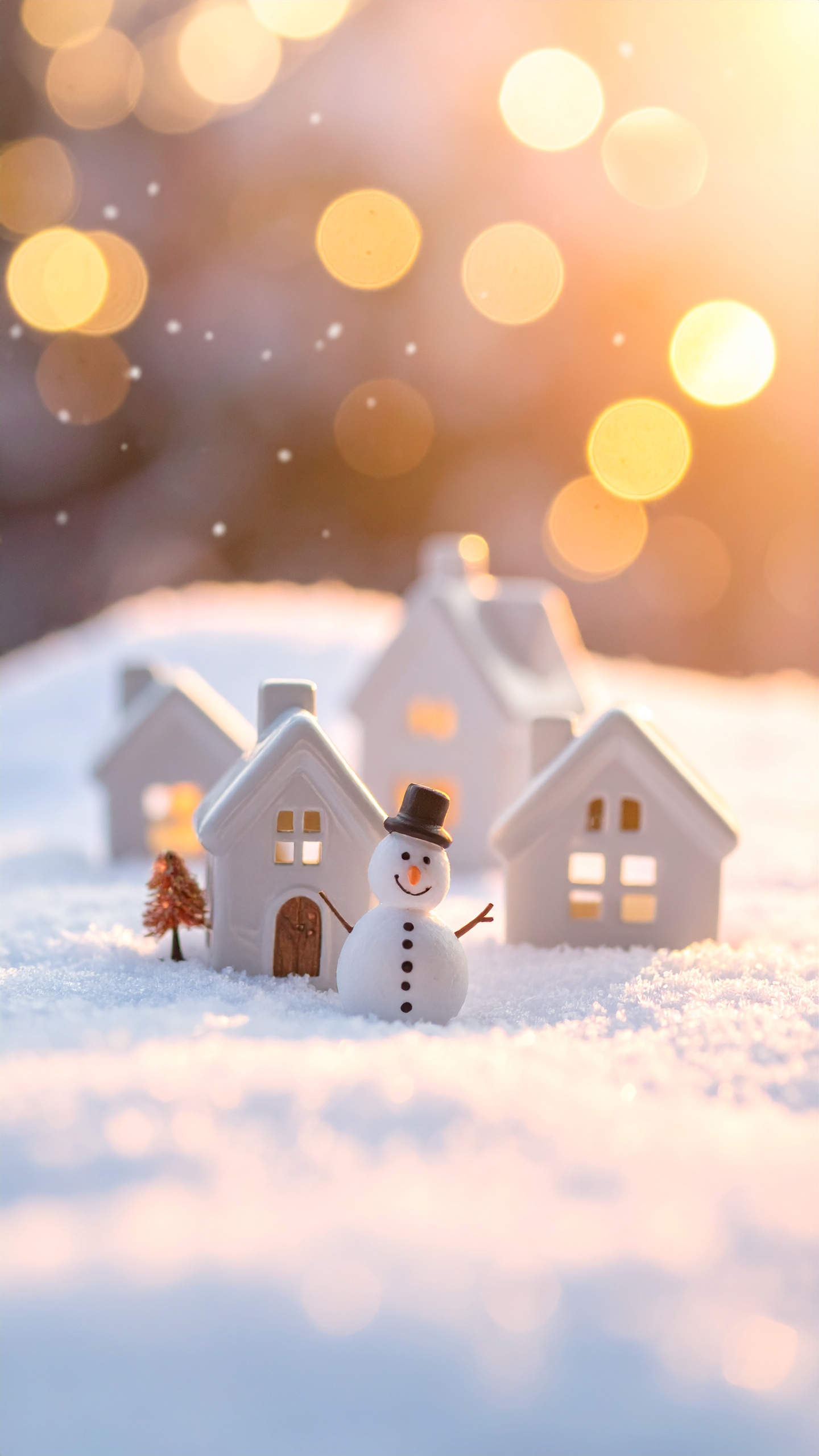 雪の中に立つシルクハットの雪だるまと、白く可愛らしいミニチュアの家々。